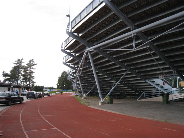 Kuva: Sotkamo Hiukan keskusurheilukentän juoksurata ja pesäpallostadionin katsomo. Vasemmalla taustalla uimarannan ja urheilukentän yhteinen päärakennus. Hilkka Högström 2011